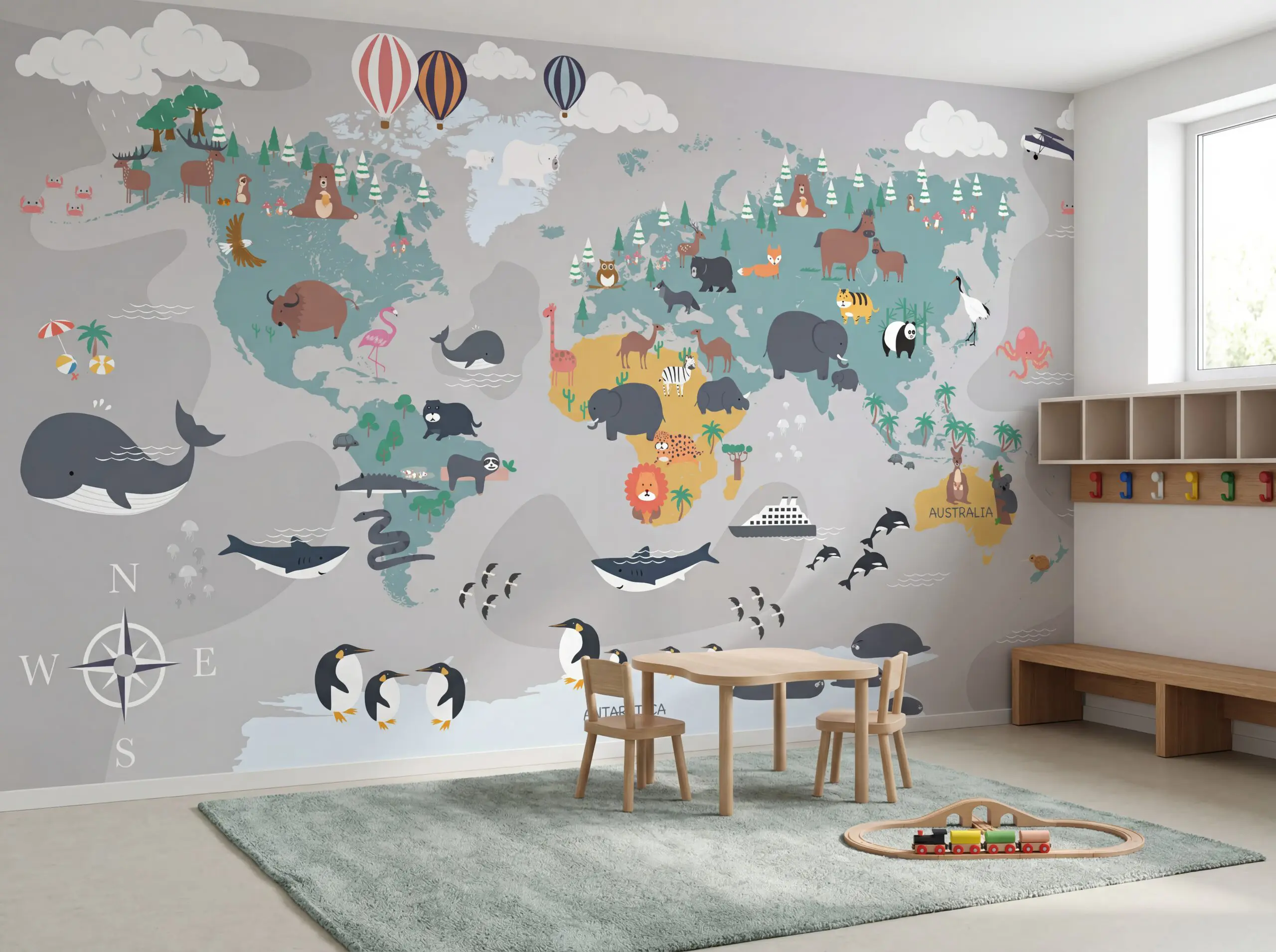 Wandkult XXL Tapetenmotiv „Tierweltkarte“ – Kinderzimmer-Weltkarte mit Kontinenten und Tierillustrationen in Grau, Blau und Grün, spielerisches Lernmotiv im skandinavischen Stil. Installiert in einem Kindergarten Eingangsbereich.